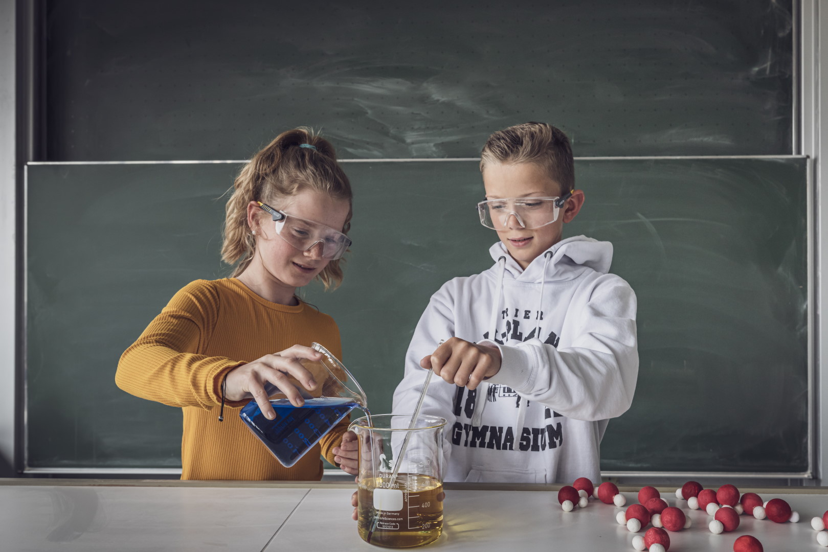 Eine Gruppe Schüler in Laborkleidung experimentiert mit Kürbissen